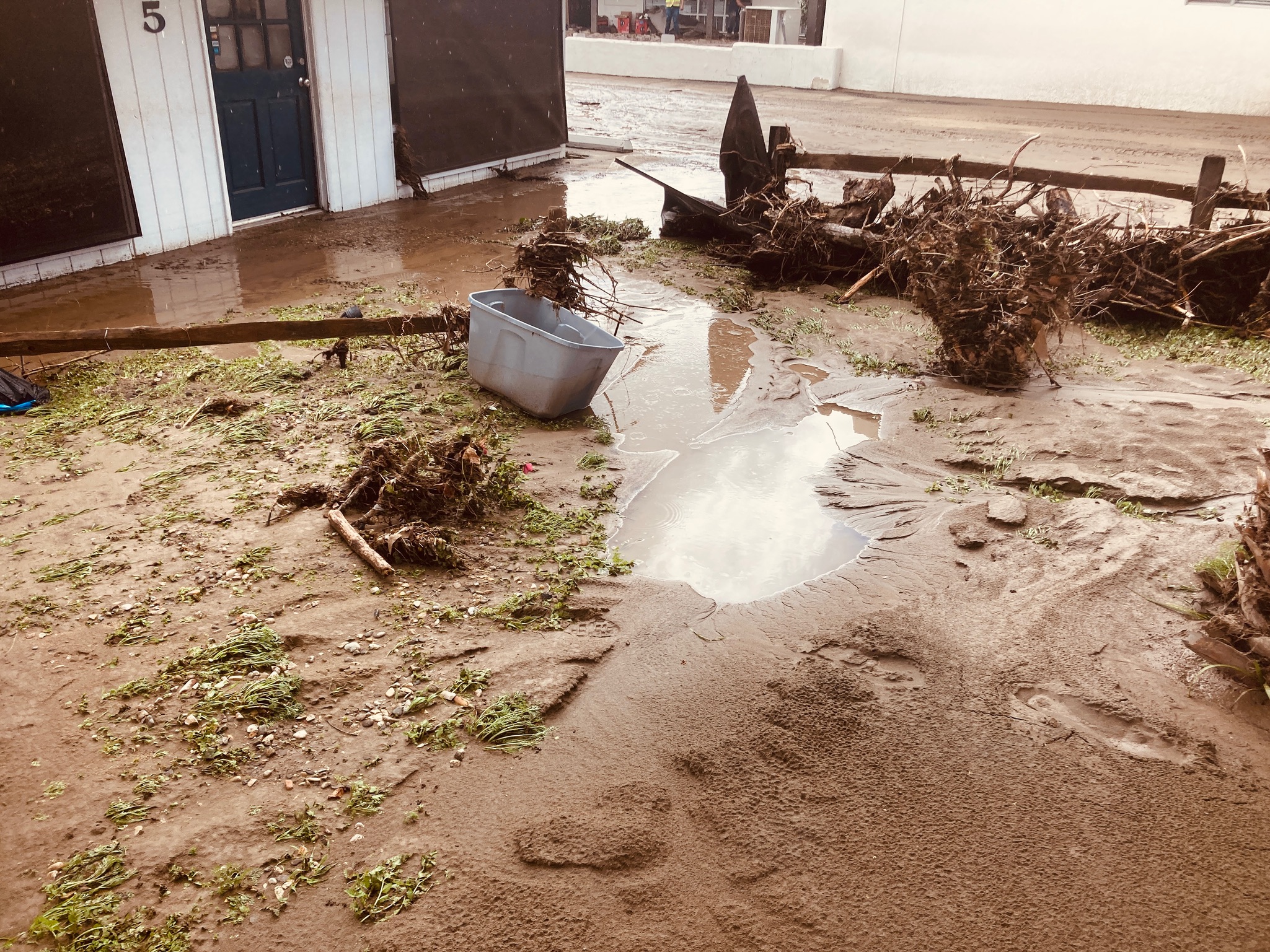 A pile of dirt beside a bucket filled with water