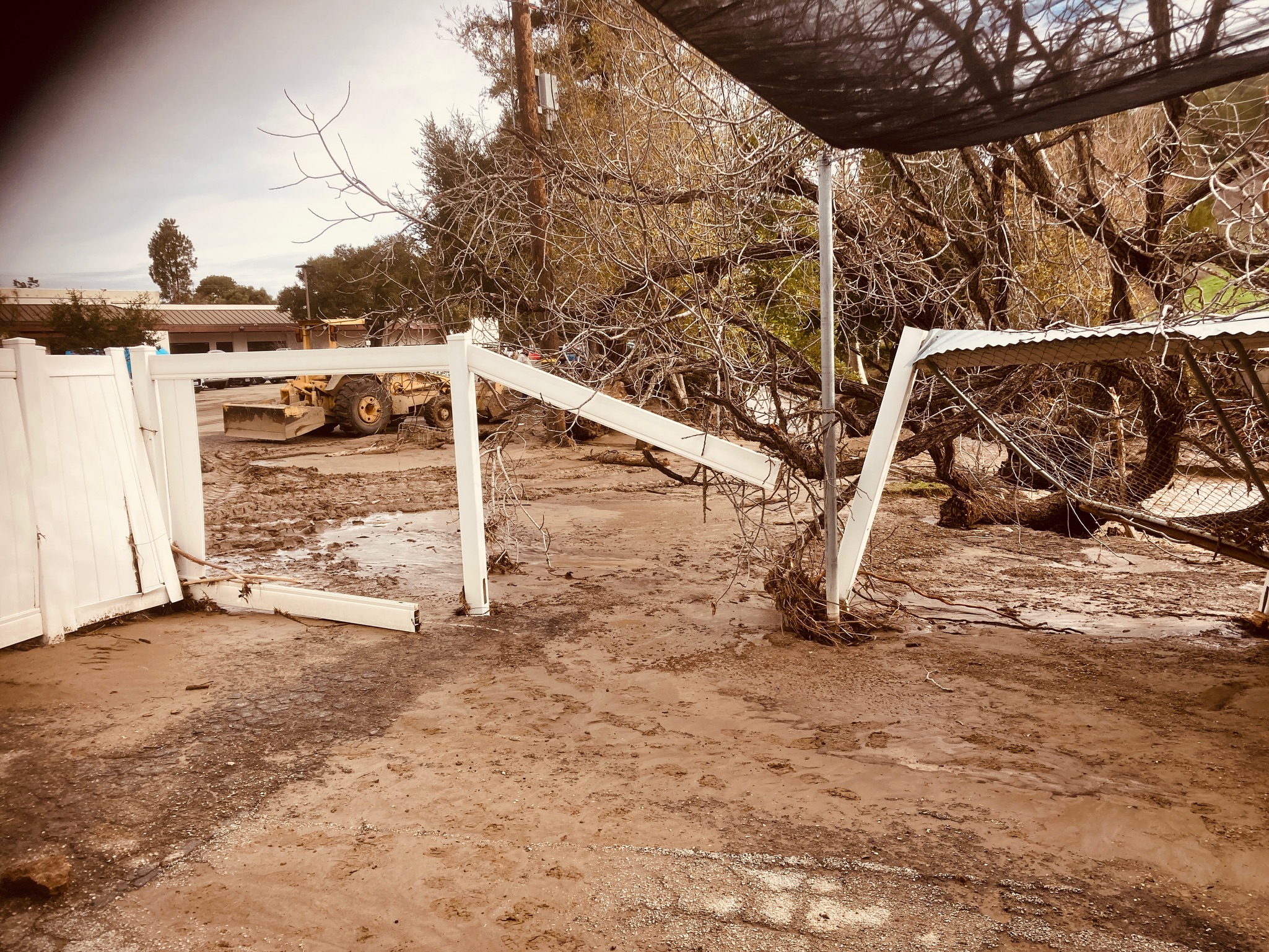 A damaged fence lies in the dirt