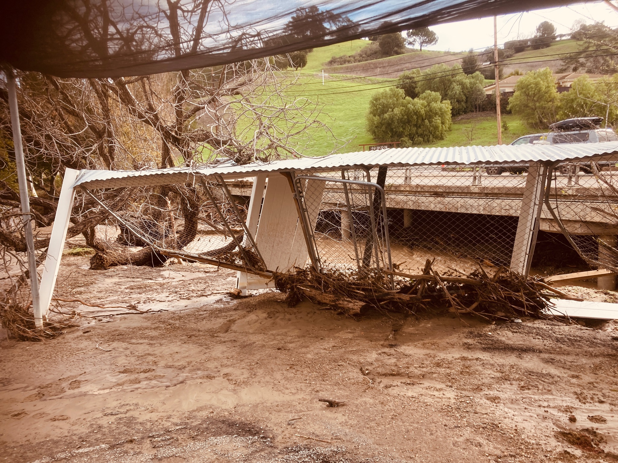 A damaged bridge partially submerged in floodwaters