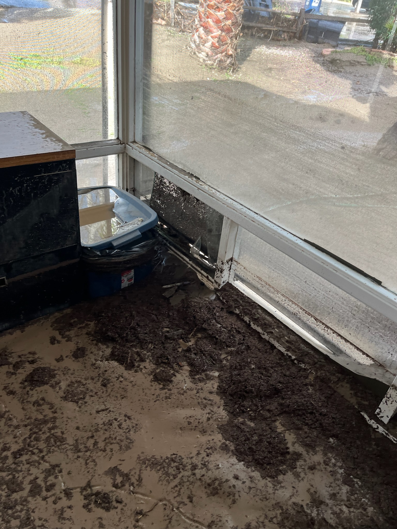 A cluttered and dirty room featuring a window and a sink