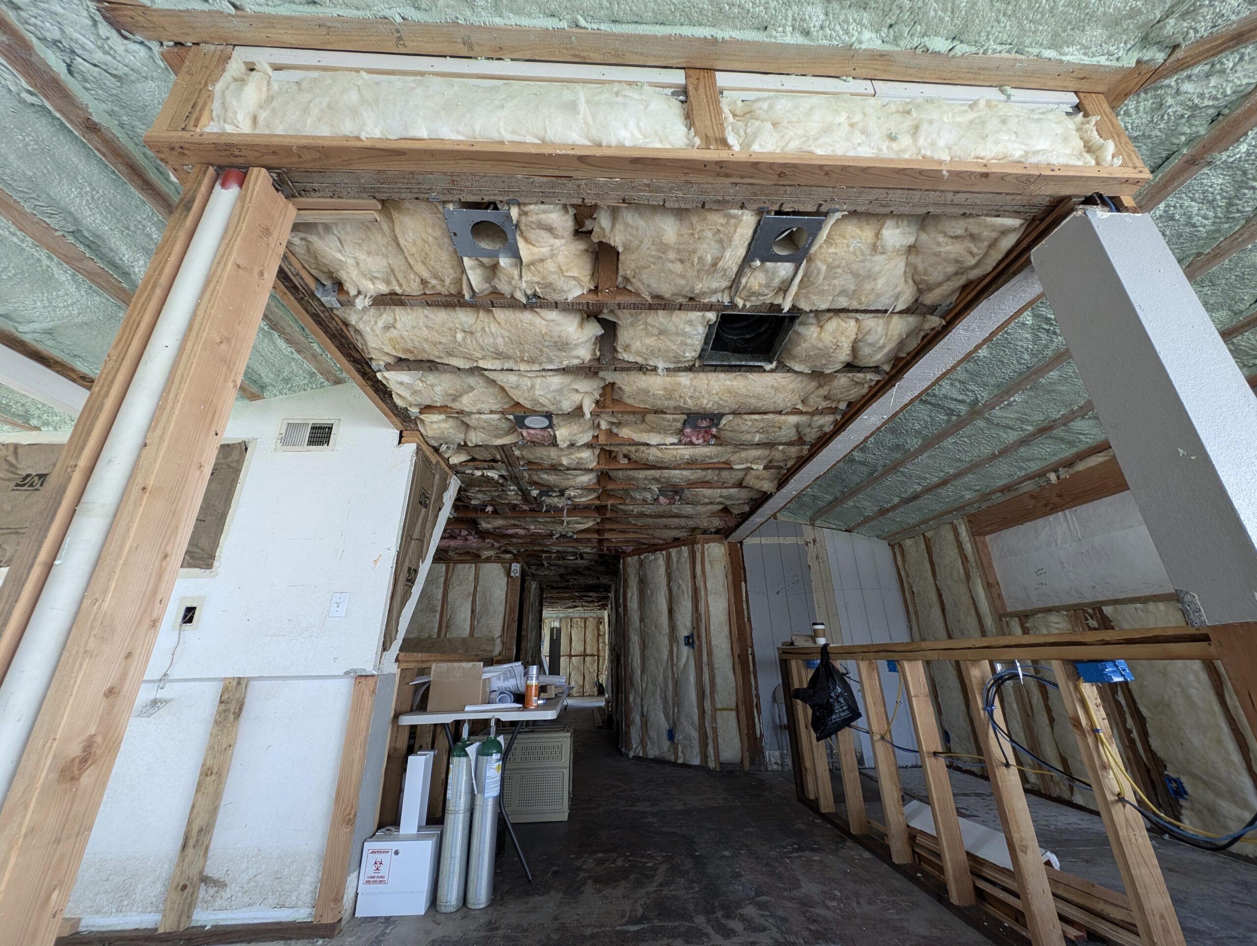 A hallway featuring exposed wood framing and insulation