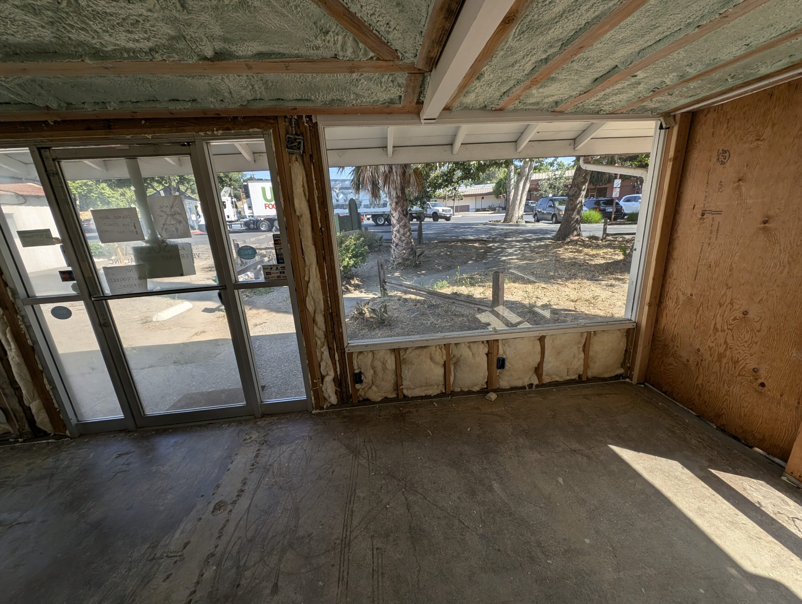 A room under renovation featuring a window and a door