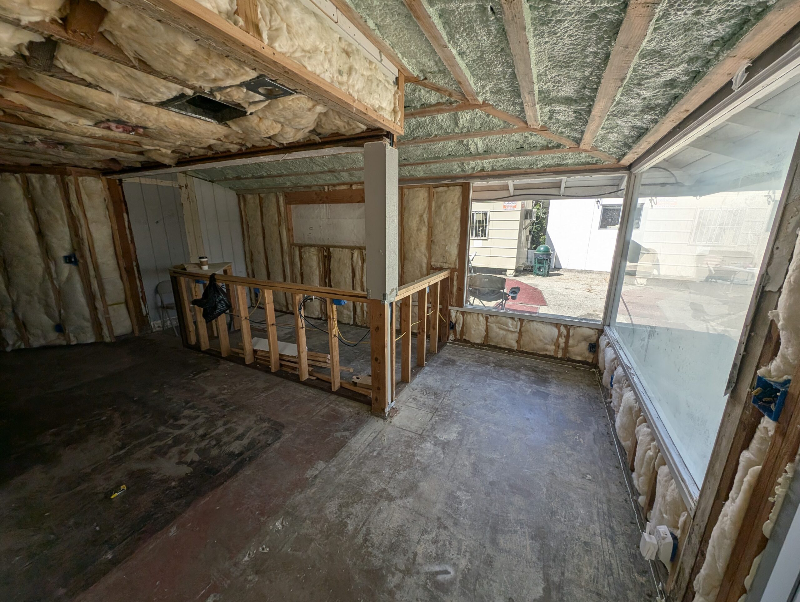 A room featuring a window and a ceiling lined with insulation material