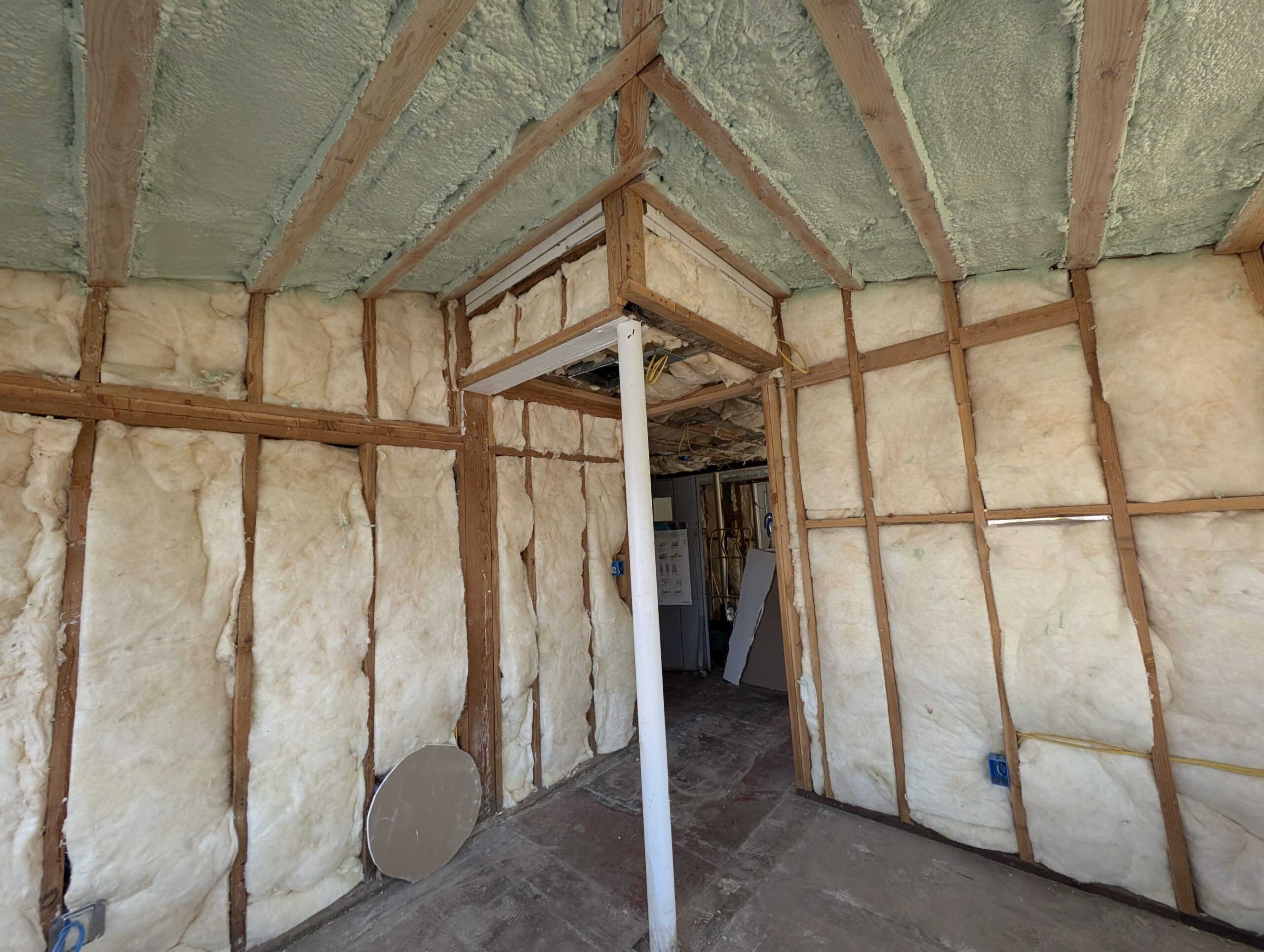 A room featuring exposed wood framing and insulation