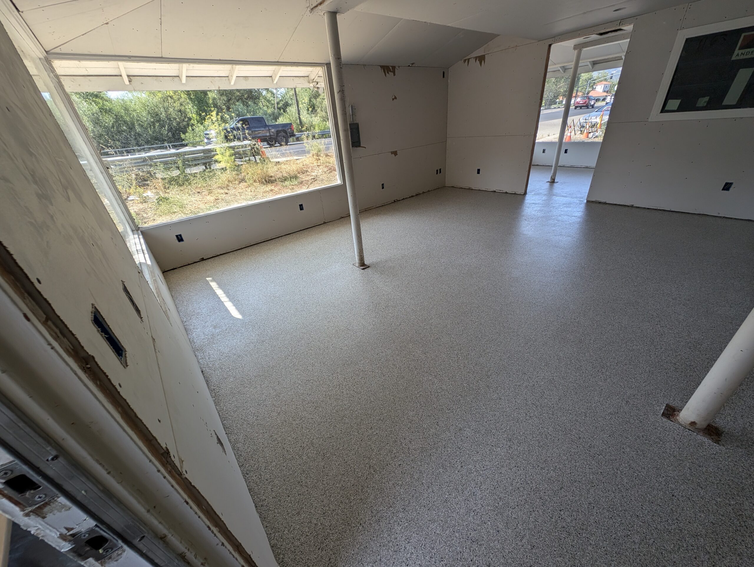A minimalist room featuring a white floor with window