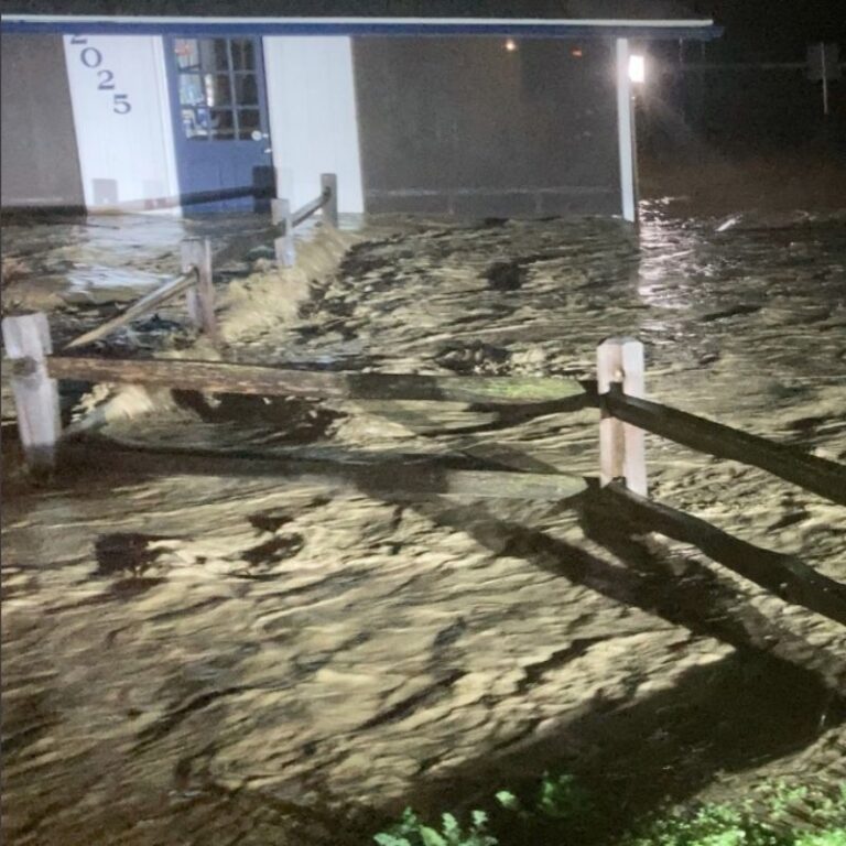 Nighttime view of a flooded parking lot adjacent to a building